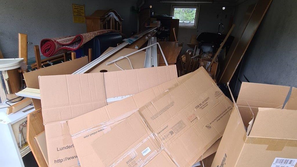 Garage voller Kartons, Möbel und Hausrat vor der Entrümpelung