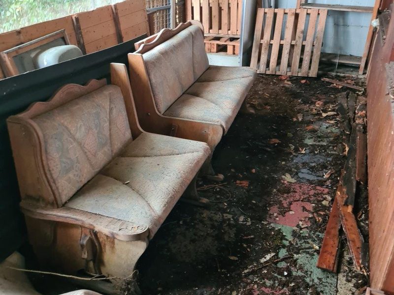 Sperrmüll: alte Sofas und Paletten in einem Anbau vor der Räumung