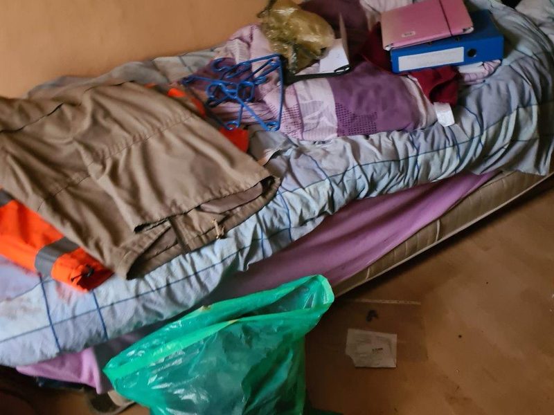 Schlafzimmer mit Matratze und Kleidung vor einer Wohnungsauflösung